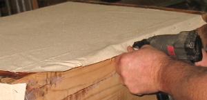 Trunk Box Fabric Being Tacked In Place With Staples